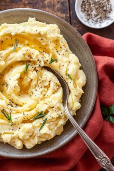 mashed potatoes with herbs and seasoning in a gray bowl on a red napkin