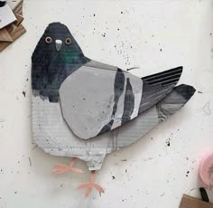 a bird made out of paper sitting on top of a table