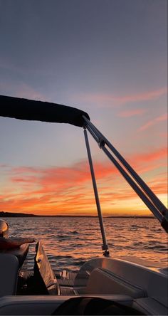 the sun is setting over the water on a boat