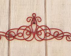 a red metal wall hanging on the side of a white wooden building with wood planks