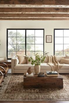 a living room filled with furniture and large windows