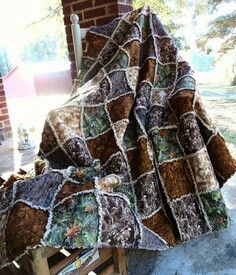 a blanket that is sitting on top of a wooden chair in front of a brick building