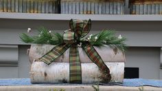 a wrapped present sitting on top of a wooden log