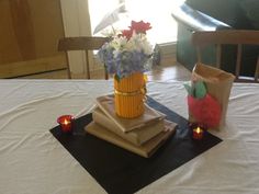 a table topped with paper bags and vases filled with flowers on top of each other