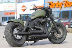 a green motorcycle parked in front of a building