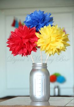 three colorful paper flowers in a mason jar