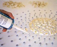 a person is using a paint roller to apply dots on a sheet of white paper