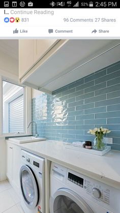 a washer and dryer in a room with blue tiles on the wall behind them