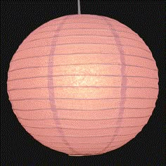 a pink paper lantern hanging from a black background