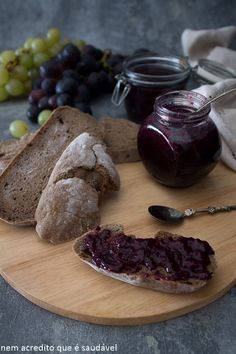 bread, jam and grapes on a cutting board