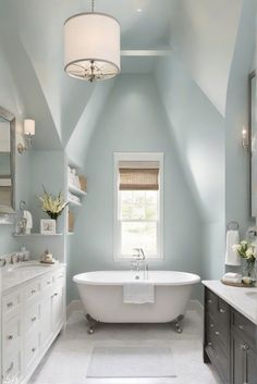 a white bath tub sitting under a window in a bathroom