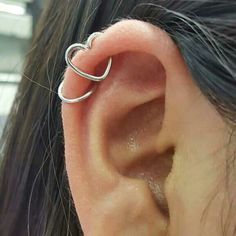 a woman's ear is shown with an open ring on it