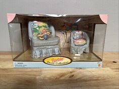 two figurines sitting on top of a wooden table next to each other in a box