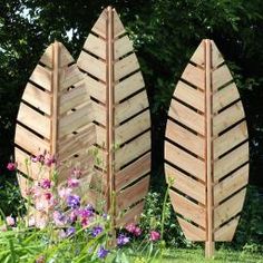 three wooden surfboards sitting next to each other in the grass