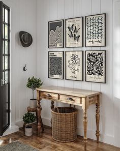 a wooden table sitting next to a wall with four pictures on it's side