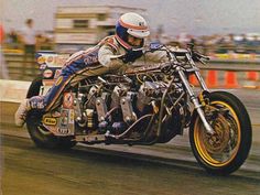 a man riding on the back of a motorcycle down a race track