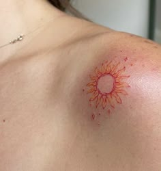 a woman with a sun tattoo on her chest