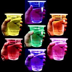 several different colored cups being held by two hands