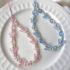 two bracelets on a white plate with pink and blue beaded necklaces next to each other