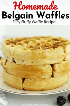 a stack of waffles sitting on top of a white plate next to blackberries