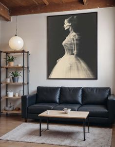 a living room with a couch, coffee table and large painting hanging on the wall