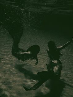 two people are swimming in the water with their arms out and legs spread wide open