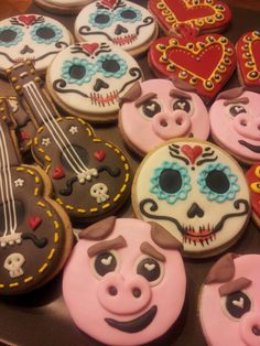 many decorated cookies are arranged on a table with guitars and skulls in the shape of hearts