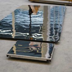 the reflection of a building in water on top of a glass table that is reflecting it's image