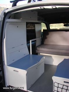 the back end of a white van with storage drawers and an open hatchback door