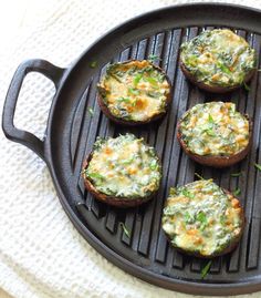 four baked goods are sitting on a grilling pan with green garnishes