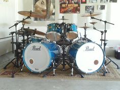 a blue drum set sitting on top of a rug in front of a white wall