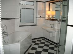 a bathroom with black and white checkered flooring, sink, toilet and bathtub