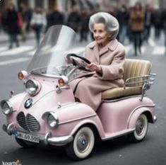 an older woman driving a pink car down the street