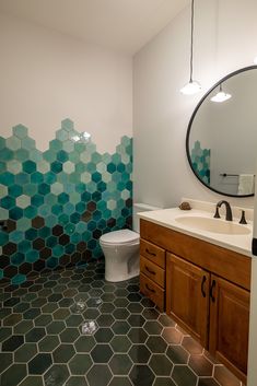 a bathroom with hexagonal tiles on the wall and floor, along with a toilet