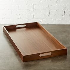 a wooden tray on a table with a brick wall in the background