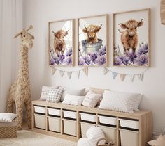 a room with three pictures hanging on the wall and two stuffed animals sitting in front of them