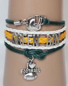 three different bracelets with football charms on each one and the word green bay written in silver