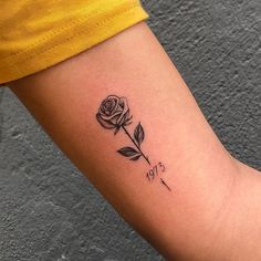 a small rose tattoo on the arm