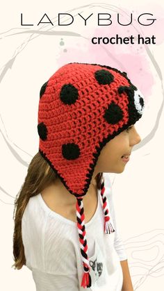 a woman wearing a red and black crochet hat with a ladybug on it