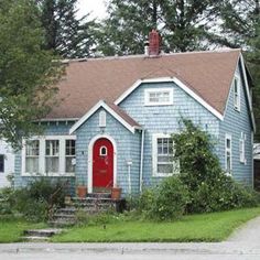 a small blue house with a red door