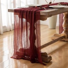 a table with a red cloth draped over it and plates on top of the table