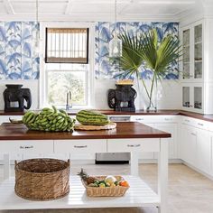 there are bananas and other fruits on the counter in this kitchen with blue wallpaper