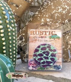 a close up of a cactus plant near a sign with the words rustic on it