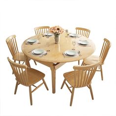 a round wooden table with four chairs around it and plates on the table, in front of a white background