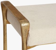 an upholstered chair with gold metal frame and fabric seat padding, viewed from the side