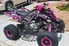 a pink and black atv is parked on the sidewalk