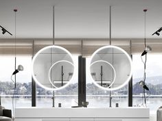 a modern bathroom with two round mirrors above the sink and large mirror on the wall