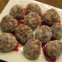 a white plate topped with chocolate covered donuts on top of a red and white table