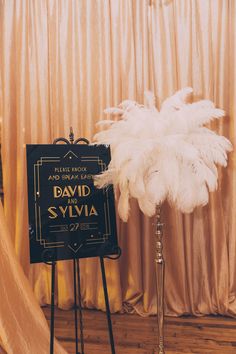 a sign that says david and svylia on it next to a tall white feather plant