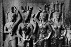 an ancient bask with three women and two men in front of it, all holding their hands up